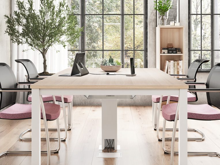 Gamme Tempo Salle de réunion moderne avec une grande table, chaises noires et plantes.