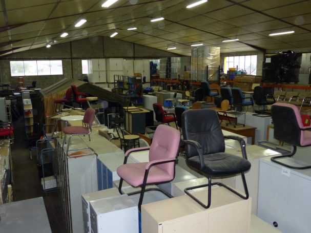 Des rows de chaises de bureau dans un entrepôt spacieux et bien éclairé.