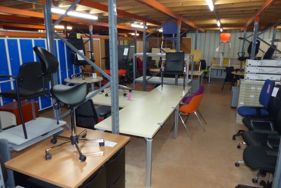Seconde main Salle remplie de chaises et de tables dans un espace de stockage.