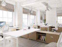 Bureau moderne lumineux avec plusieurs postes de travail, chaises ergonomiques et fenêtres.