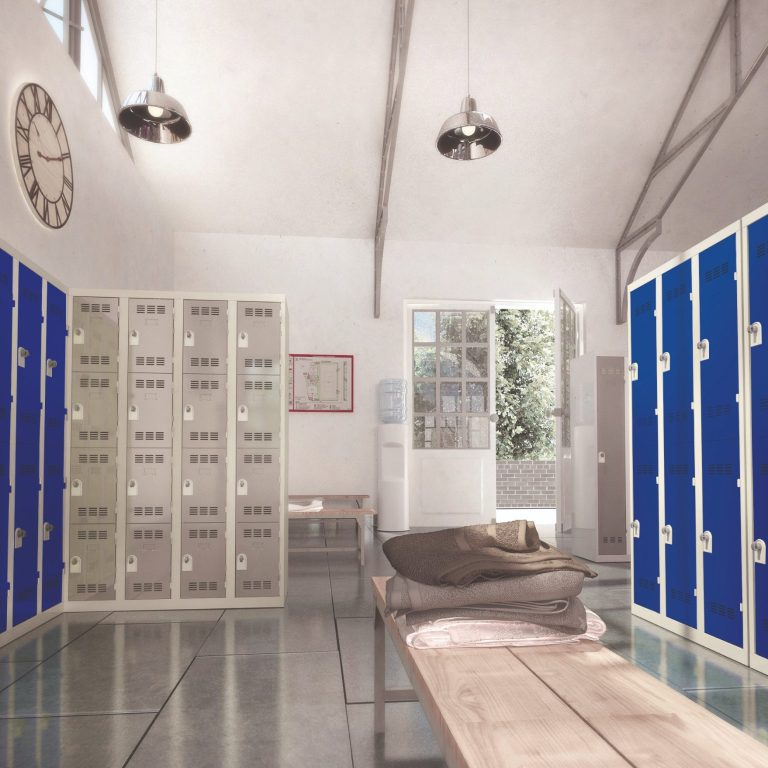Intérieur d'une salle avec casiers bleus et un lit simple, éclairé par la lumière naturelle.