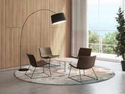 Espace de vie moderne avec chaises, table et lampe sur un tapis circulaire.